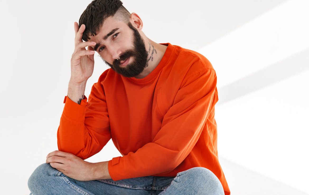image-of-young-bearded-man-sitting-isolated-over-w-84SVLHT