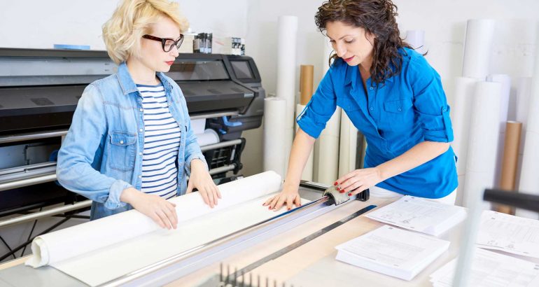 women-cutting-paper-in-printing-shop-DGH9QFZ