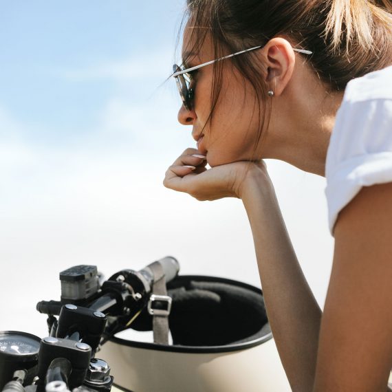 biker-girl-sitting-on-vintage-custom-motorcycle-PRER32L
