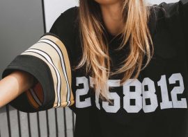 girl-in-hockey-jersey-style-with-street-bicycle-PEKUWLK