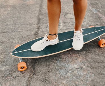 woman-in-sneakers-riding-skateboard-outdoor-on-asp-KXD8CUS