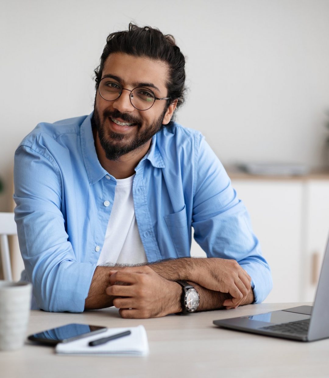 freelance-career-handsome-indian-guy-sitting-at-la-7GSJQSC