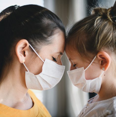 mother-and-child-with-face-masks-indoors-at-home-c-R6CGLQB